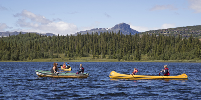 To kanoer og en robåt ute på Bamselitjern. Fjellet "Bitihorn" i bakgrunnen. Foto: Thor Østbye